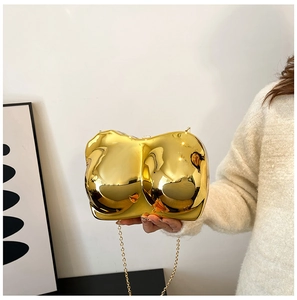 Detail of gold mirror acrylic bra-shaped evening clutch with gold metal chain strap