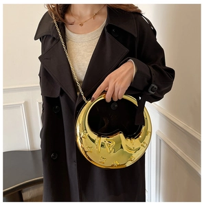 Glossy gold crescent moon handbag with star patterns and a delicate metal chain strap
