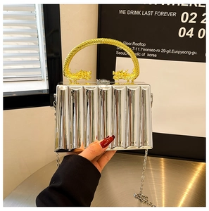 Detailed view of silver ripple texture box bag with gold double dragon handles