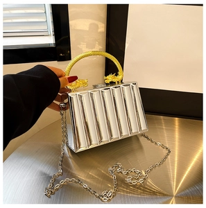 Detail of acrylic box bag with ice-crack texture and golden dragon-shaped handle