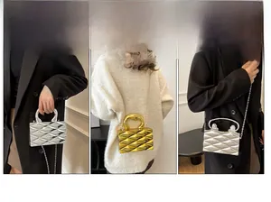 Dettaglio borsa da sera geometrica in acrilico con finitura metallica e catenella
