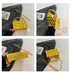 Dettaglio della borsa clutch in acrilico dorato con trama a diamante 3D e catena
