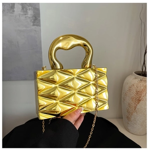 Dettaglio borsa da sera dorata in acrilico con trama geometrica 3D e manico curvo