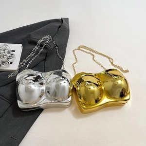 Avant-garde bra-shaped acrylic clutch bag with metallic gold and silver finish and chain