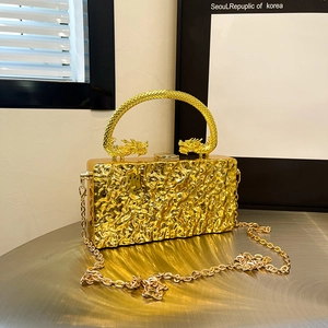 Gold acrylic evening clutch with carved dragon handle and molten metal texture