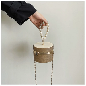 Detail of crystal rhinestone evening bag with pearl handle and golden chain strap