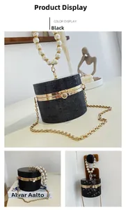 Macro shot of black rhinestone cylindrical evening bag with large pearl handle