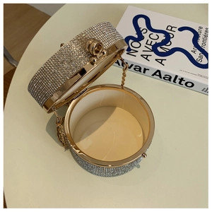 Detail view showing inner beige lining and crystal embellished exterior of the round clutch