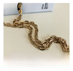 Close-up of high-quality polished gold metal chain strap for acrylic cylinder handbag