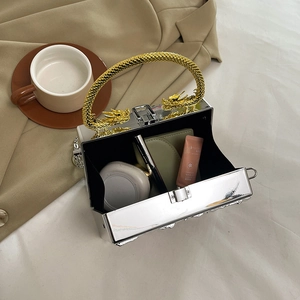 Silver mirror acrylic clutch bag with ornate golden dragon handles and black interior