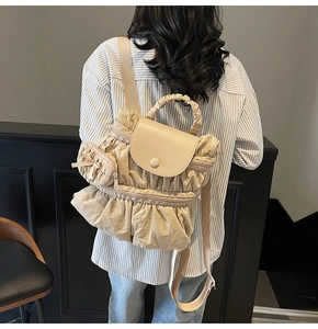 Detail van een beige geplooide rugzak op model met grote capaciteit en zachte textuur