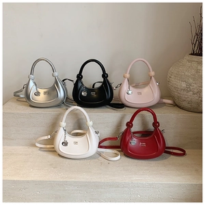 Dettaglio di cinque borse a mezzaluna in pelle nei colori argento, nero, rosa, bianco e rosso