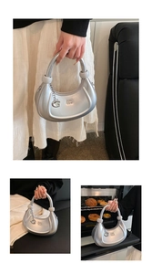 Dettaglio della borsa hobo argento metallizzato con sfere decorative e ciondolo a G
