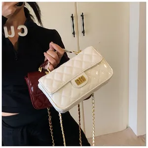 Detail view of quilted patent leather crossbody bags with golden chain and metal locks