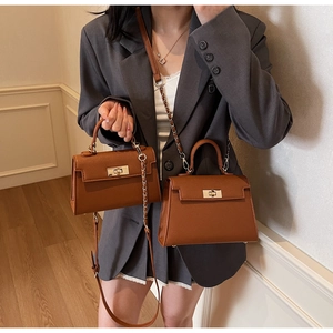 Close-up of caramel leather Kelly style handbags with gold hardware in two sizes