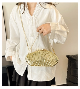 Detail view of the golden shell-textured acrylic evening clutch bag with round bead chain