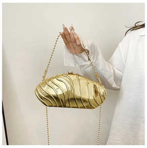 Close-up of golden wavy evening clutch with metallic mirror finish and bead chain strap