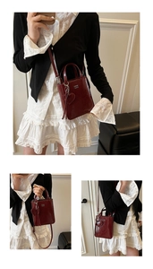 Detail of burgundy glossy leather mini tote with silver logo and heart pendant decoration