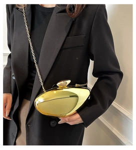 Close-up of golden pebble-shaped evening clutch with elegant metallic mirror finish