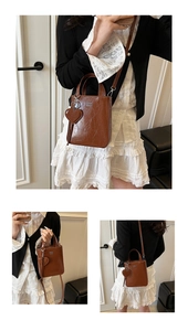 Detail of vintage brown mini crossbody bag with heart charm and COIN ZDN metal logo