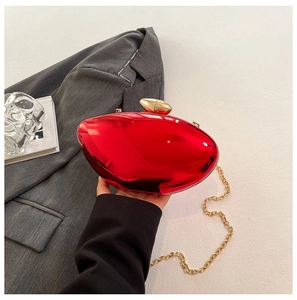 Detailed close-up of glossy red mirror evening clutch with a golden metallic handle