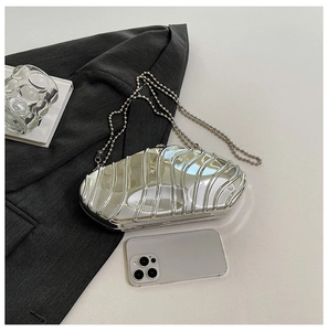 Macro view of silver wave texture acrylic evening clutch bag with metallic chain strap