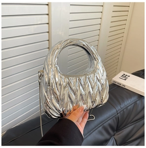 Detail of silver pleated quilted clutch bag with curved handle and metal chain
