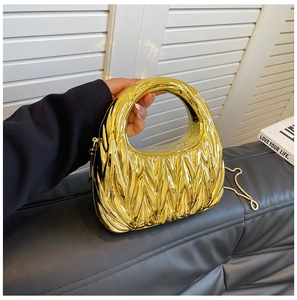 Close-up of golden metallic crescent bag featuring elegant pleated texture and chain strap