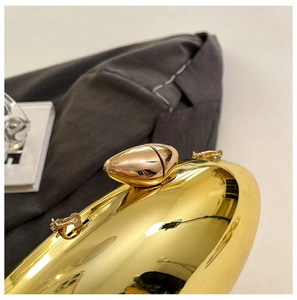 Close-up of luxury gold evening clutch bag with glossy metallic finish and water-drop clasp