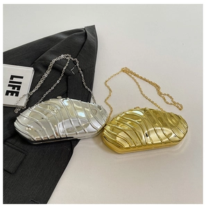 Detail of shell-shaped acrylic evening clutches in gold and silver with wave texture