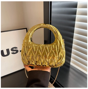 Detail of gold metallic crescent pleated handbag with round handle and elegant chain strap