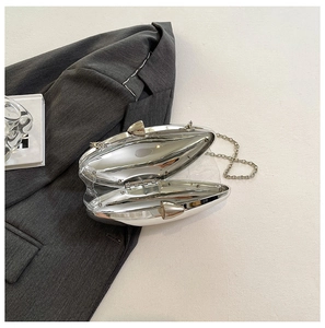 Macro view of silver mirror-finish evening clutch bag with slim metal chain strap