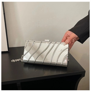 Detail of silver metallic clutch with vertical ripple texture and long chain strap