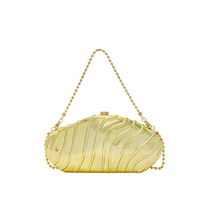 Detail of gold hard-shell evening clutch bag with wavy striped texture and chain strap