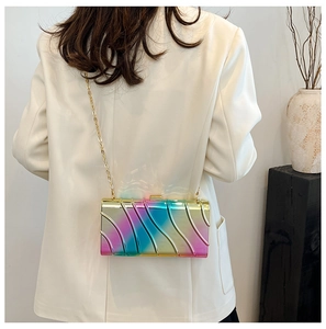 Iridescent wavy textured acrylic evening bag with gold chain shown on a model