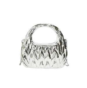 Close-up of silver matelassé pleated evening bag with chain strap and top handle