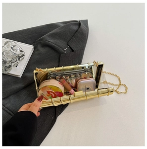 Close-up of golden bamboo texture evening clutch bag showing internal storage for phone