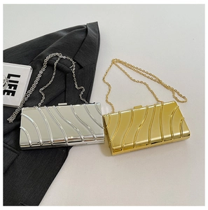 Detail of gold and silver clutch bags with textured metallic finish and chain straps