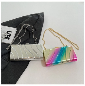 Detail of metallic wavy clutch bags in silver and rainbow colors with chain straps