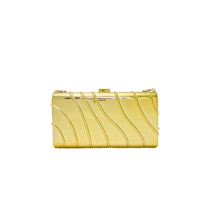 Detail of gold hard shell evening clutch featuring vertical wave textures and top metal clasp