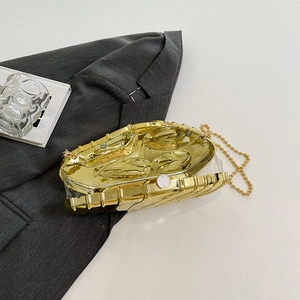 Elegant gold textured metal clutch bag with white round clasp and chic beaded chain strap