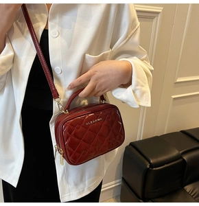 Détail du mini sac matelassé bordeaux avec double fermeture éclair dorée et sangle
