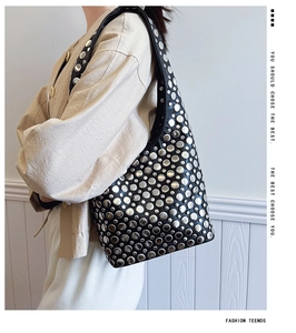 Vue détaillée du sac hobo noir avec des rivets décoratifs en métal argenté