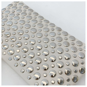 Detailed close-up of textured white PU leather with silver studded rivet embellishments