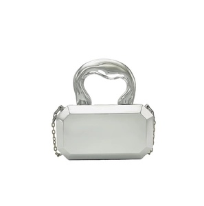 Detail van zilveren achthoekige hardcase clutch met vloeibaar metalen handvat en ketting