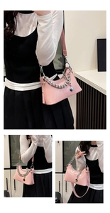 Detail of pink oil wax leather crescent bag featuring a chunky silver chain and strap