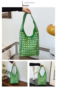Détail d'un sac à épaule en cuir vert orné de rivets métalliques ronds argentés