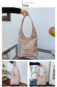 Sac hobo rose avec rivets argentés et large bandoulière dans un décor intérieur