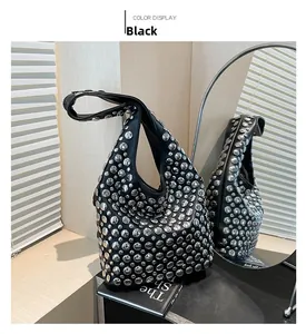 Detail der schwarzen Hobo-Tasche aus Leder mit silbernen Nieten und breitem Gurt