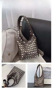 Gros plan détaillé du sac hobo en cuir marron avec des rivets ronds argentés décoratifs